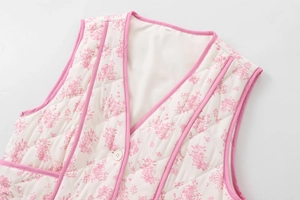 Detail of floral quilted vest with pink piping and elegant diamond stitch patterns