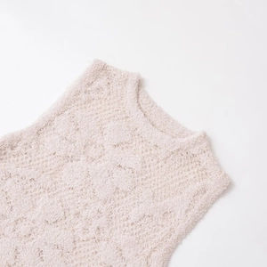Gros plan sur un débardeur en maille rose à fleurs avec une texture bouclée élégante