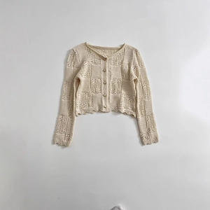 Gilet élégant en maille crochet beige avec découpes géométriques et bords festonnés