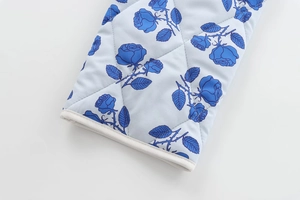 Close-up of quilted floral fabric with blue rose prints and diamond stitching detail
