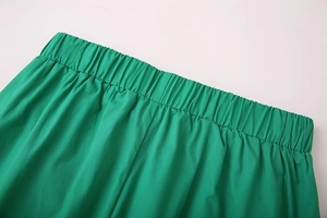 Detailed macro view of the elastic waistband on bright green woven fabric trousers