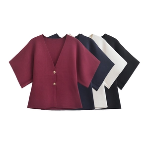 Detailed flat lay of knitted cardigans showing V-neckline and metal button fasteners