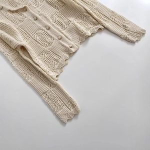 Gilet en maille ajourée chic avec boutons vintage et bordures festonnées en blanc crème