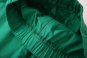 Detail view of emerald green elastic waistband with high-quality reinforced stitching