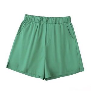 Detail of high-waist bean green casual shorts with elastic waistband and side slit design