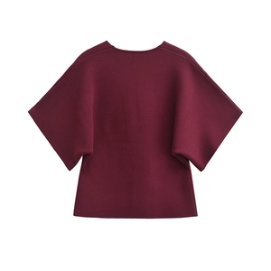 Detail of burgundy knitted cardigan with wide short sleeves and fine texture