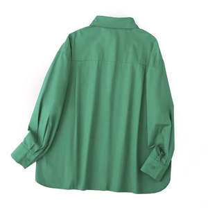 Detail view of the back of a green oversized long-sleeved shirt with a curved hemline