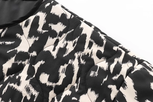 Détail du tissu matelassé avec imprimé floral, bordure noire et coutures de qualité