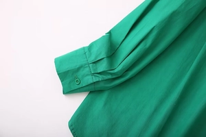 Detailed view of emerald green shirt cuff with single button and premium stitching