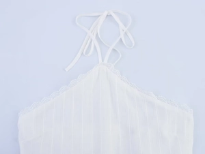 Detailed view of the white ribbed halter top featuring delicate lace trim and neck ties