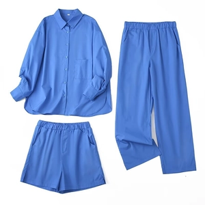 Detailed flat lay of light blue three-piece set with button shirt, pants and shorts