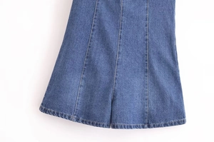 Détail macro de l'ourlet d'une jupe en jean bleu avec coutures verticales précises