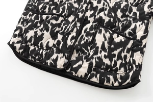Détail de veste matelassée à motif léopard abstrait avec des boutons-pression