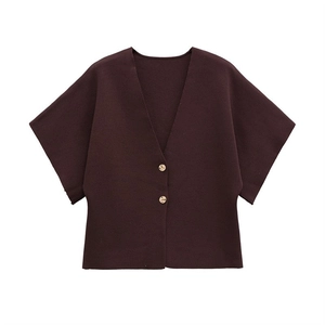 Detail of burgundy short sleeve knit cardigan featuring V-neck and golden button accents