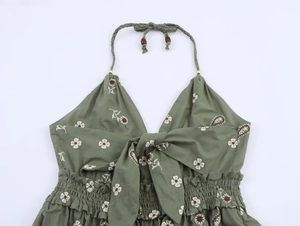 Detail eines armeegegrünen Neckholderkleids mit Blumenstickerei und Holzperlen