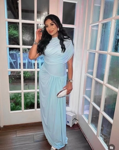 Detail showing elegant light blue pleated maxi dress with one-shoulder design and slim fit cut