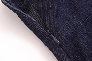 Détail du haut en jean bleu foncé avec fermeture éclair invisible et texture en sergé