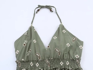 Detail eines olivgrünen Boho-Tops mit Blumenstickerei und geflochtenem Neckholder mit Holzperlen