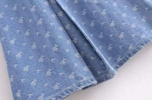 Close-up of blue denim fabric with white logo prints and professional stitching