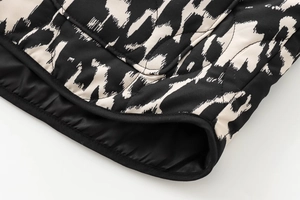 Gros plan sur la veste matelassée à imprimé animal avec bordure noire et détails de couture
