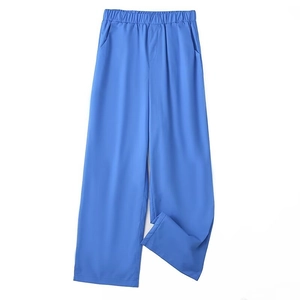 Detail of high-waisted sky blue wide-leg trousers with pleated elastic waist and pockets