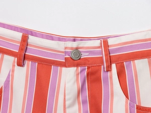 Close-up of waist detail on vertical striped shorts with metal button and belt loops