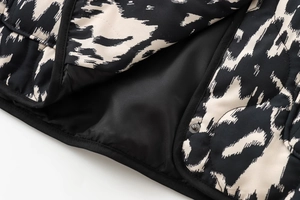 Détail d'une veste matelassée à imprimé zèbre avec boutons-pression et doublure noire