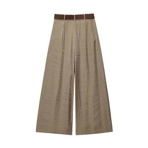 Détail du pantalon large en satin champagne avec effet métallisé et ceinture marron foncé