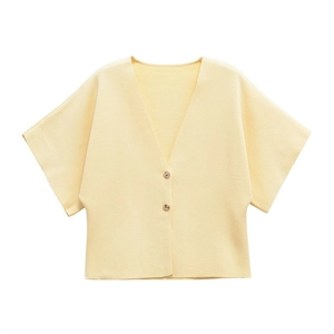 Close-up of light yellow knit cardigan with V-neckline and two amber buttons