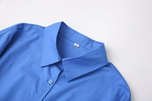 Detail view of royal blue shirt collar featuring stitching and a white size S label