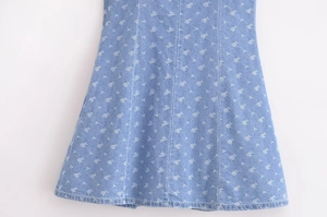 Detail of light blue denim dress hem with floral print and vertical panel stitching