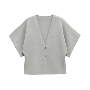 Detail of grey-blue knit cardigan showing ribbed texture and amber textured buttons