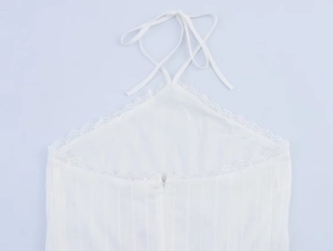 Close-up of white halter neck top with vertical stripes and delicate lace edges