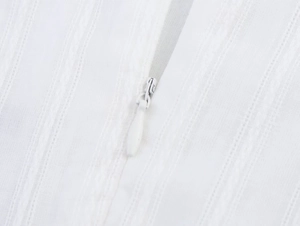 Detail of white summer dress showing fabric texture and invisible water-drop zipper