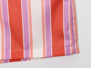 Close-up of vertical red and purple striped twill fabric with precise stitching detail