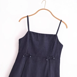 Top caraco en jean bleu foncé avec fines bretelles et détails de nœuds à la taille sur cintre