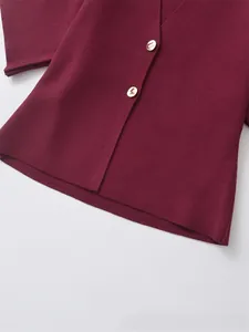Macro detail of dark red knit cardigan hem with premium round gold metallic buttons