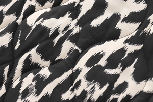 Détail macro du tissu matelassé avec imprimé animalier noir et blanc poli