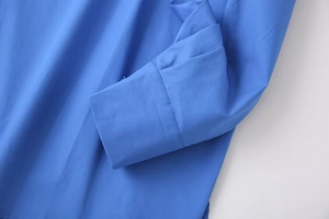 Detailed macro shot of royal blue blouse cuff with high-quality stitching and fabric texture