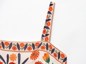 Close-up of bohemian floral print and strap detail on a summer sundress fabric