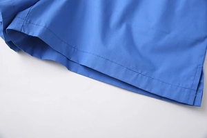 Close-up of bright blue polyester shorts showing high-quality stitching and side slit detail