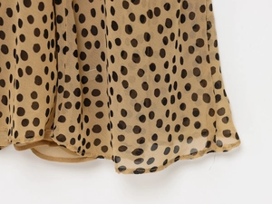 Detailansicht des khakifarbenen Polka-Dot-Chiffon-Kleidsaums mit feiner Rollnaht-Verarbeitung