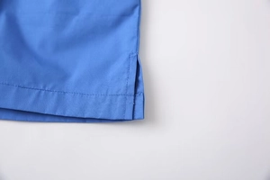 Detail of blue high-waisted shorts with side split hem and double needle stitching