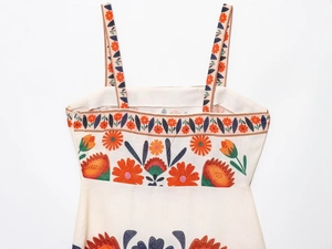 Detailed close-up of bohemian floral print and invisible zipper on linen strap dress
