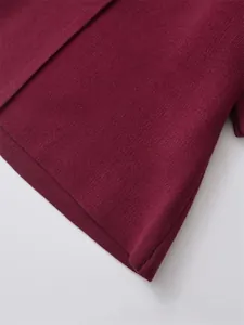 Close-up of wine red knitted cardigan fabric showing high-quality dense texture and finish