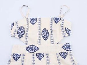 Detailed close-up of Bohemian leaf embroidery and delicate vertical lace on a summer midi dress