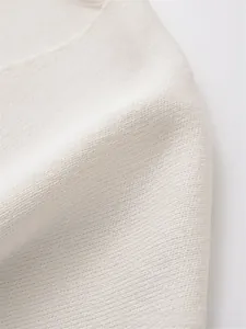 Detailed macro shot of white high-density knitted fabric texture for autumn cardigan