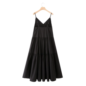 Detail of a black tiered midi dress featuring a V-neck and adjustable spaghetti straps