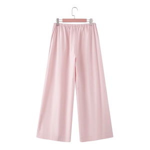 Detailed view of pink high-waisted wide-leg trousers with elastic waistband and linen texture
