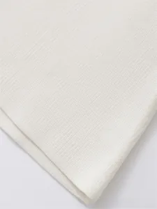 Close-up of white ribbed knit fabric showing detailed texture and vertical patterns